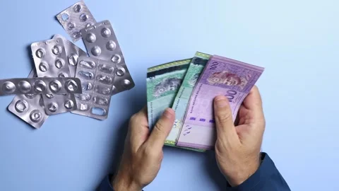 Empty pill blisters and man's hands counting Malaysian ringgit (MYR) banknotes. Stock Footage 303341916