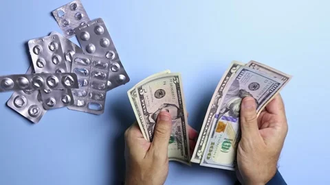 Empty pill blisters and man's hands counting American dollars (USD) banknotes. Stock Footage 303346317