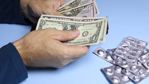 Empty pill blisters and man's hands counting American dollars (USD) banknotes. Stock Footage 303361947