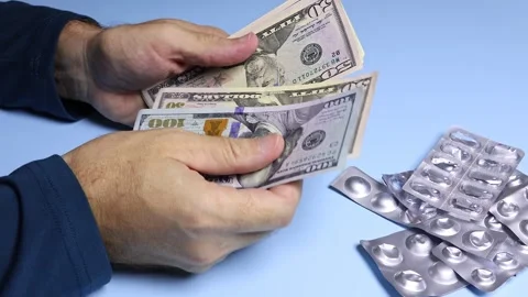Empty pill blisters and man's hands counting American dollars (USD) banknotes. Stock Footage 303362066