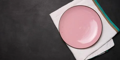 Empty pink ceramic plate on black table, top view Stock Photos
