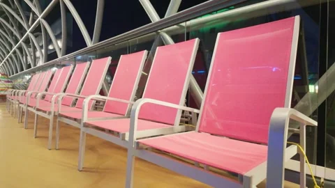 Empty Pink Lounge Chairs Lined Up Along Modern Cruise Ship Deck at Night Vídeo Stock 346926288