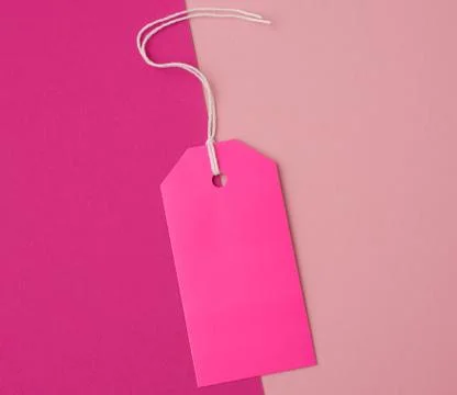 Empty pink paper rectangular tag on a rope on a colored background Stock Photos