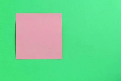 Empty pink sticker note on a green background. Business concept Stock Photos