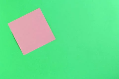 Empty pink sticker note on a green background. Business concept Stock Photos