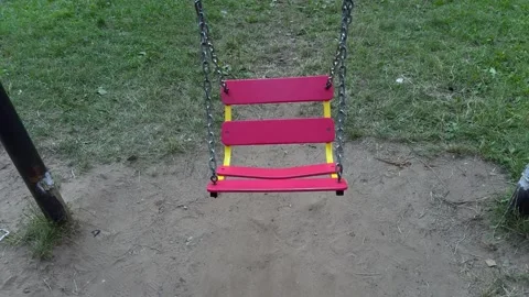 Empty pink swing on chains over sand in an outdoor playground Stock Footage 341510294