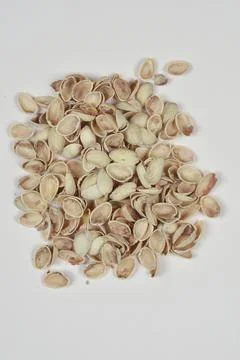 Empty pistachio nutshells pile on beige background. Stock Photos