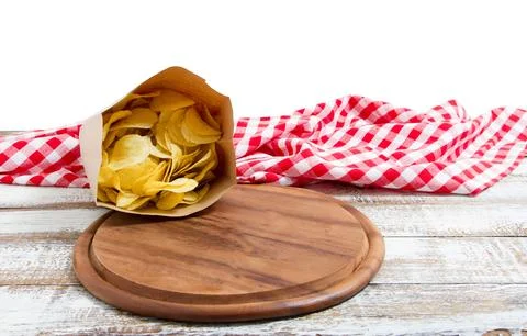 Empty pizza board and tablecloth and potato chips pack on table isolated on.. Stock Photos