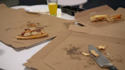 Empty pizza boxes, leftovers on kitchen table, home needs cleaning after party Video stock 120992548