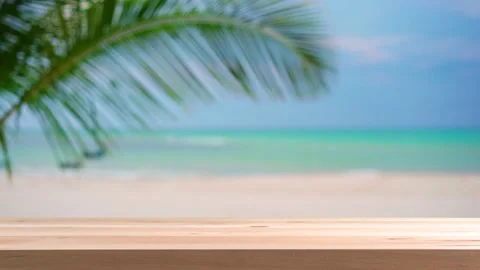 Empty plank wooden table with palm leaf and beautiful tropical white sand beach Видео 197096497