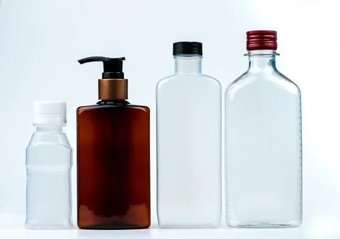 Empty plastic and glass bottle with cap and pump with black label isolated .. Stock Photos