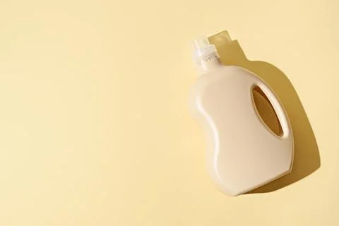 Empty plastic beige container, bottle on yellow background, mock up Stock Photos