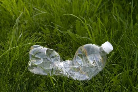 Empty plastic bottle are lying on the grass Stock Photos