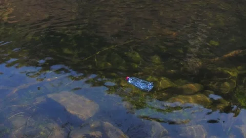 Empty plastic bottle garbage floating in clear river. Close up. 4K Stock Footage 171479750