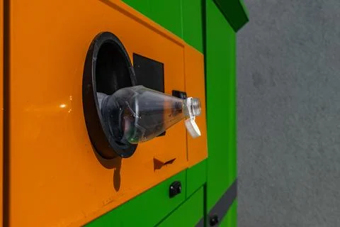An empty plastic bottle sticking out of a used packaging collection machine.. Stock Photos