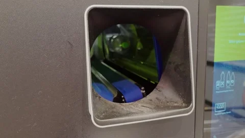 Empty plastic bottles are inserted into a recycling deposit machine at a Ge.. Stock Footage 345166048