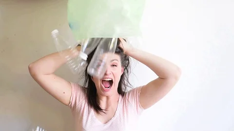 Empty plastic bottles are pouring on the girls head. Stock Footage 129506270