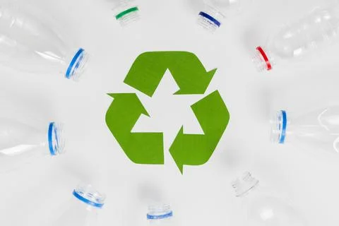 Empty plastic bottles around recycling icon Stock Photos