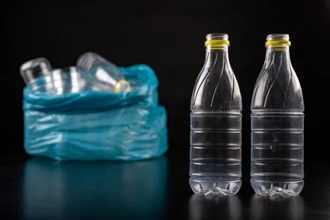 Empty plastic bottles in a garbage bag. Household waste collected in a blue b Stock Photos