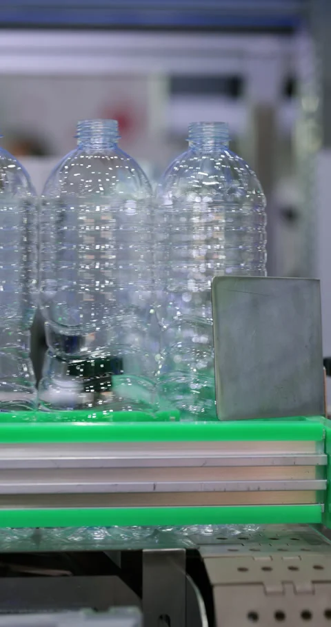 Empty plastic bottles grouped and moving together on conveyor in factory Stock Footage 346704784