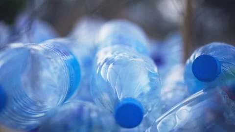 Empty plastic bottles lying outdoors on sunny day. Stacked garbage waste close Video stock 158247016