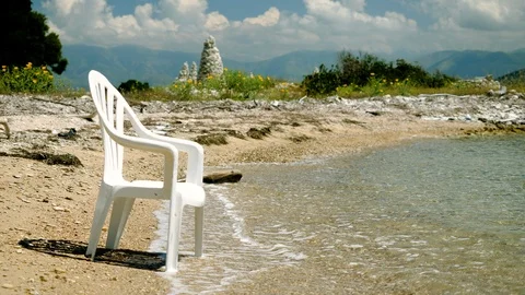 An empty plastic chair left on shore of the Mediterranean sea. Greece. 4K Stock Footage 118911255