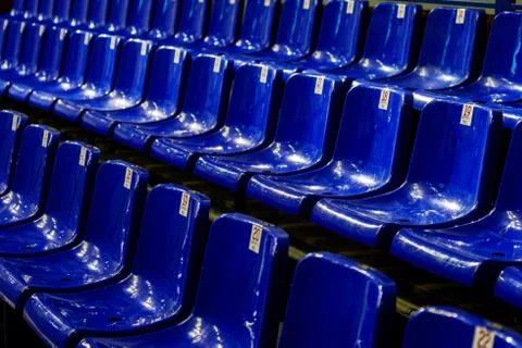 Empty plastic chairs in the stands of the stadium. Many empty seats for spect Stock Photos