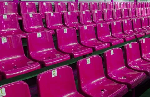 Empty plastic chairs in the stands of the stadium. Many empty seats for spect Stock Photos