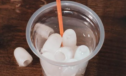 An empty plastic cup is filled with ice for cocktails. Stock Photos