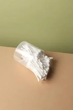 Empty plastic cup tipped over with cotton swabs inside Stock Photos