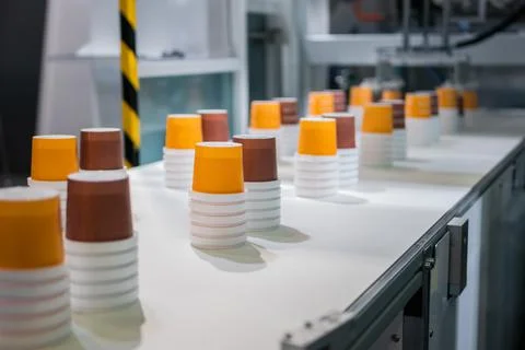 Empty plastic cups moving on conveyor belt at package exhibition Foto stock