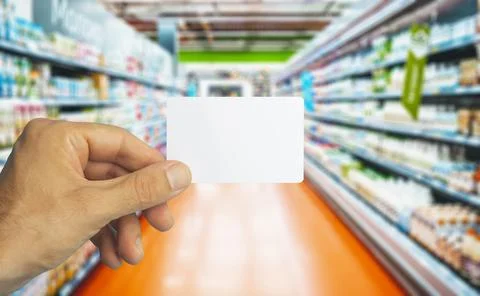 Empty plastic grocery card in hand on supermarket background. Grocery card fo Foto stock