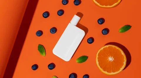 Empty plastic sun protection bottle with oranges, berries and mint Stock Photos