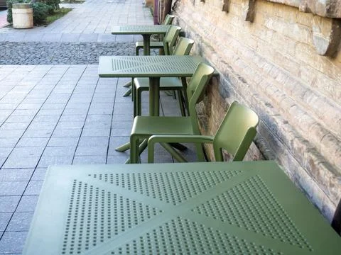 Empty plastic tables in a cafe. Green chairs and tables outside. The concep.. Stock Photos