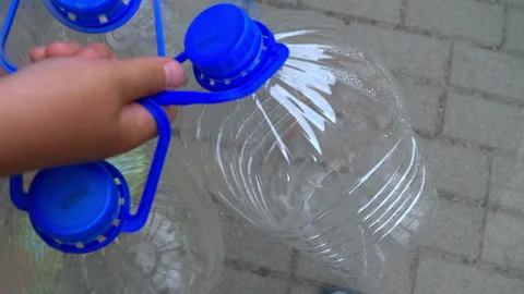 Empty plastic water bottles are thrown into the trash. Video stock 270936091
