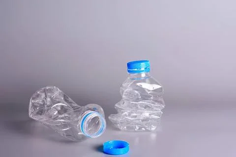 Empty plastic water bottles with caps on gray background Stock Photos