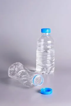 Empty plastic water bottles with caps on plain background Stock Photos