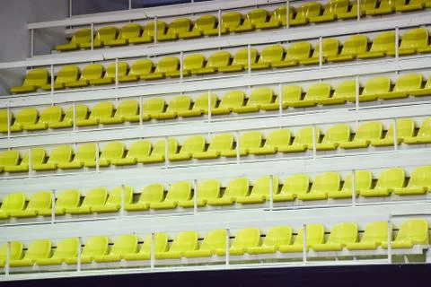 Empty plastic yellow seats row at stadium indoor show or sport field place Stock Photos