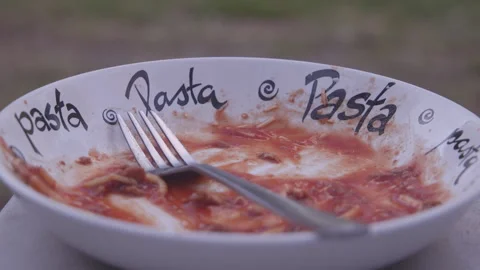 Empty plate after delicious pasta meal with fork resting beside it Stock Footage 323869417