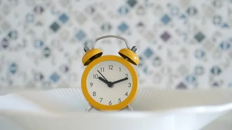 Empty plate with alarm clock front view, intermittent fasting concept. Stock Footage 292863036