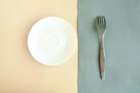 Empty plate and fork on grey and yellow background. Copy space for the text.  Stock Photos