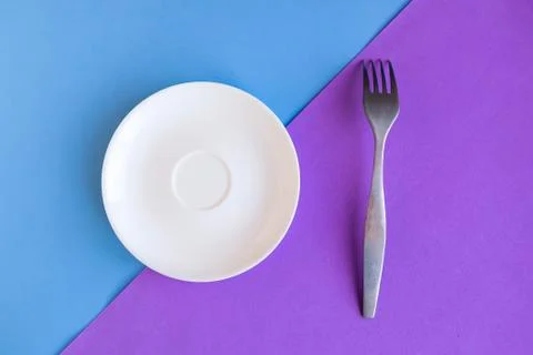 Empty plate and fork on grey and yellow background. Copy space for the text.  Stock Photos