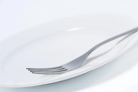 Empty plate and fork Stock-Fotos