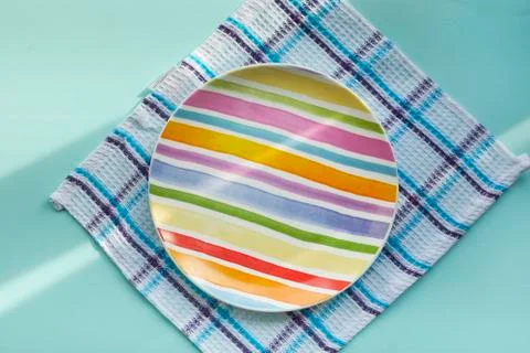 Empty plate on a blue background, covered with the rays of the morning sun Foto stock