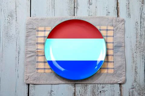 Empty plate with Dutch flag on light blue wooden background Stock Photos