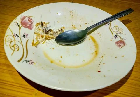 An empty plate with fish bones and a spoon Stock Photos