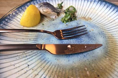 Empty Plate with Fish Bones and Lemon Wedge After Meal Stock Photos