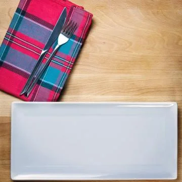 Empty plate with fork and knife on wooden table, table arrangement Stock Photos