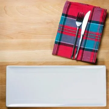 Empty plate with fork and knife on wooden table, table arrangement Stock Photos