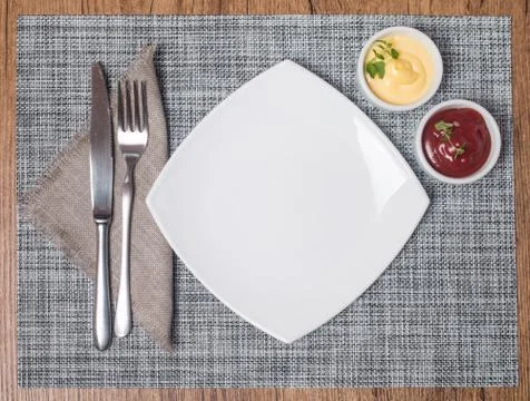 Empty plate with fork and knife, ketchup and mayonnaise Stock Photos